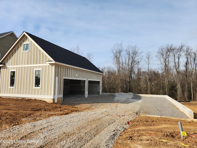 view of outbuilding with a garage and gravel driveway