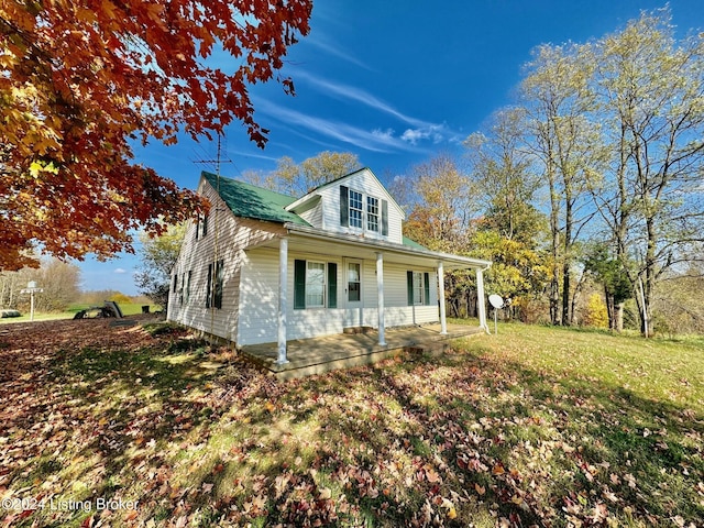 view of side of property featuring a porch and a lawn