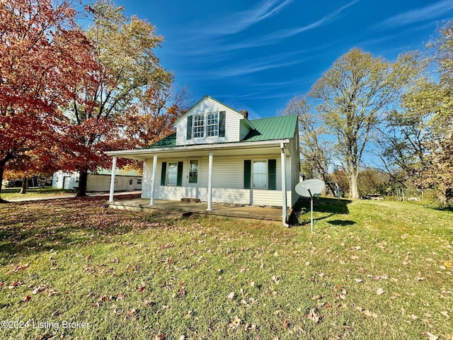 view of front of property featuring a porch, metal roof, and a front lawn