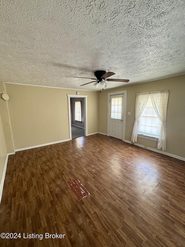 unfurnished living room featuring a ceiling fan, a textured ceiling, baseboards, and wood finished floors