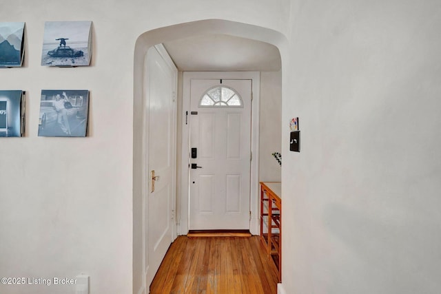 doorway to outside featuring arched walkways and wood finished floors