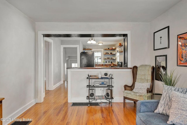 living area with light wood-style floors and baseboards