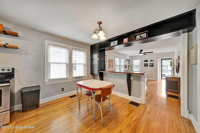 dining area with light wood finished floors, baseboards, and visible vents