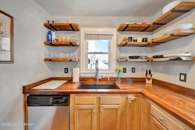 kitchen with a sink, butcher block countertops, open shelves, and stainless steel dishwasher