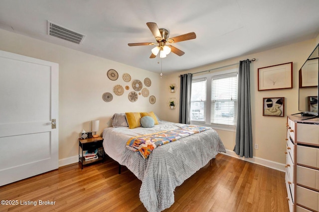 bedroom with light wood-type flooring, baseboards, visible vents, and a ceiling fan