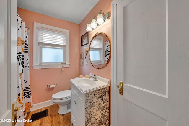 full bath featuring visible vents, toilet, vanity, wood finished floors, and baseboards