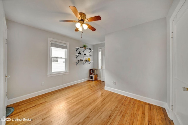 spare room featuring ceiling fan, light wood-style flooring, and baseboards