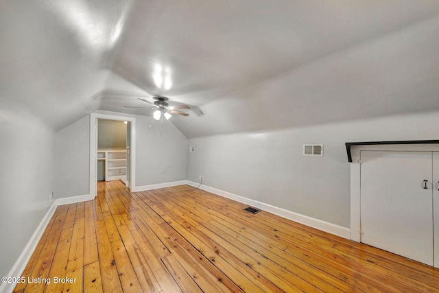 bonus room with lofted ceiling, light wood-style floors, baseboards, and visible vents