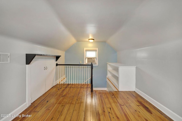 bonus room with vaulted ceiling, visible vents, hardwood / wood-style flooring, and baseboards