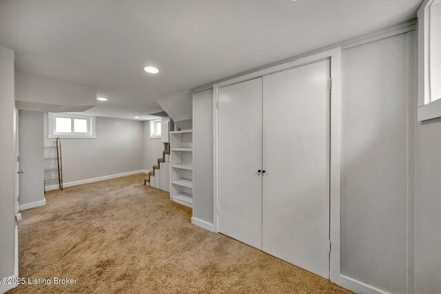 below grade area featuring carpet floors, stairway, recessed lighting, and baseboards