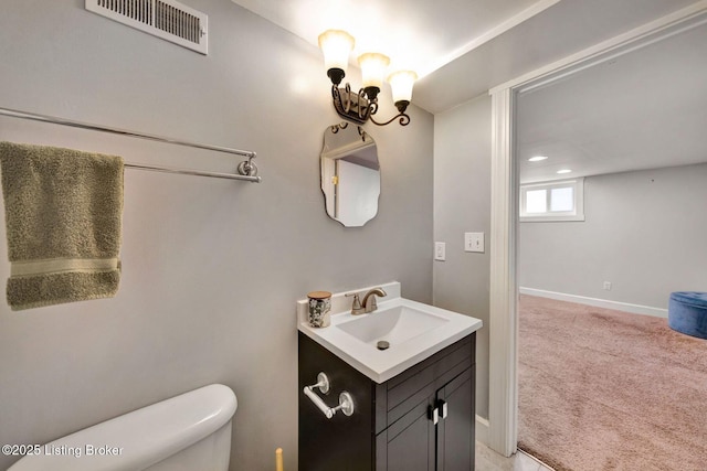 bathroom featuring baseboards, visible vents, vanity, and toilet