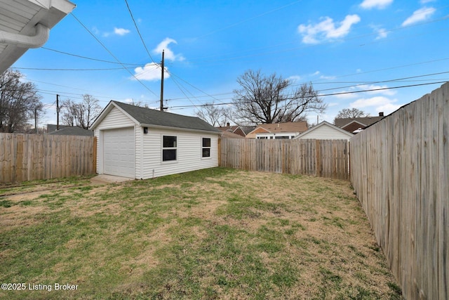 view of yard featuring a detached garage, a fenced backyard, and an outdoor structure