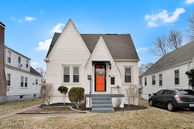 view of front of home featuring a front yard and roof with shingles