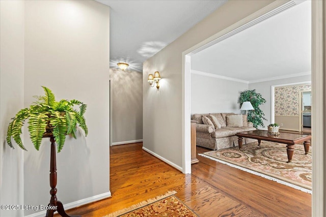 hall featuring ornamental molding, wood finished floors, and baseboards