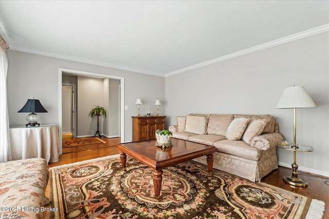 living area with ornamental molding, wood finished floors, and baseboards