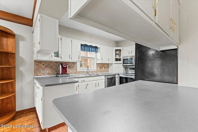 kitchen featuring white cabinetry, appliances with stainless steel finishes, decorative backsplash, and a sink