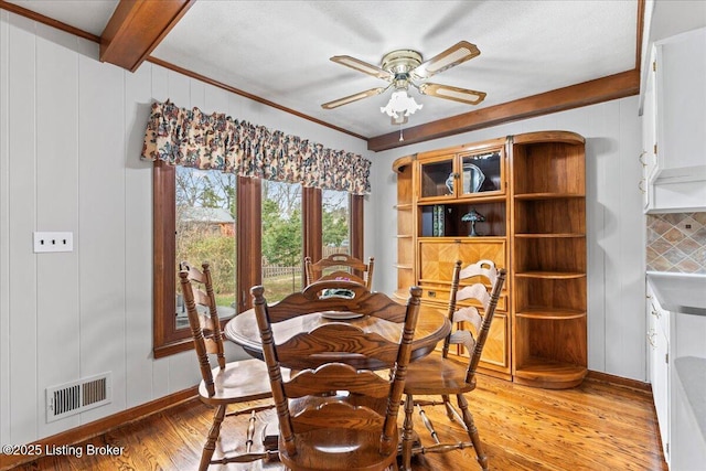 dining area with ceiling fan, beam ceiling, visible vents, and light wood-style floors