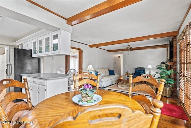 dining room featuring ornamental molding, beamed ceiling, ceiling fan, and wood finished floors