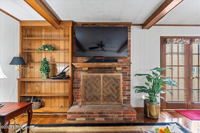 room details featuring wood walls, a fireplace, wood finished floors, and beam ceiling