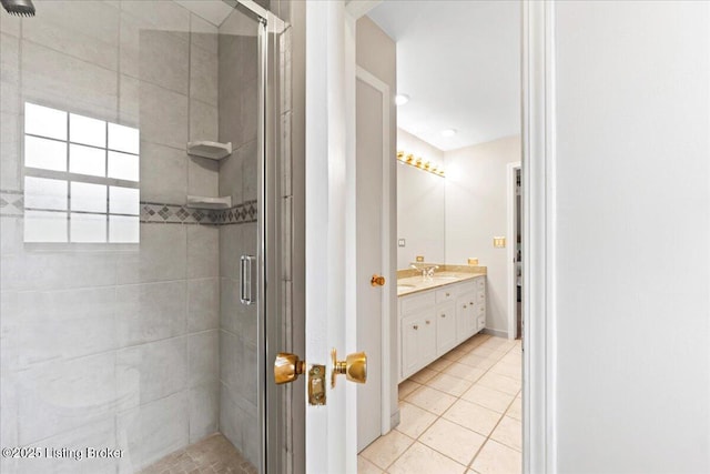 full bathroom with a stall shower, tile patterned flooring, and vanity