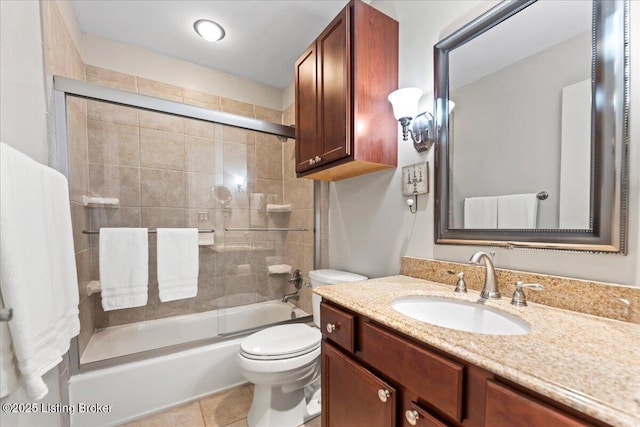 full bathroom with combined bath / shower with glass door, vanity, toilet, and tile patterned floors