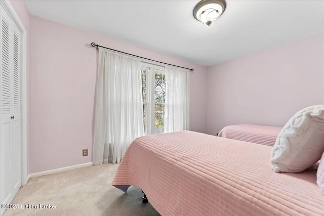 carpeted bedroom with baseboards and a closet