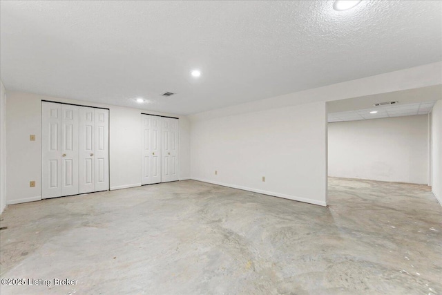 finished below grade area featuring recessed lighting, visible vents, and baseboards