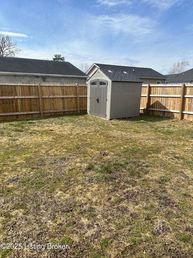 view of yard with a storage unit, an outbuilding, and a fenced backyard