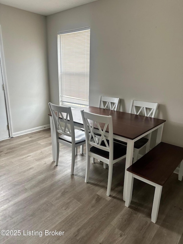 dining room featuring baseboards and wood finished floors