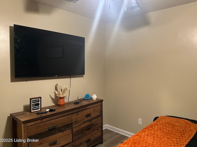 bedroom with dark wood-type flooring and baseboards