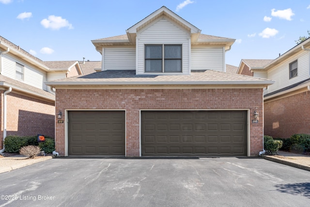 view of front of property with aphalt driveway, brick siding, and roof with shingles