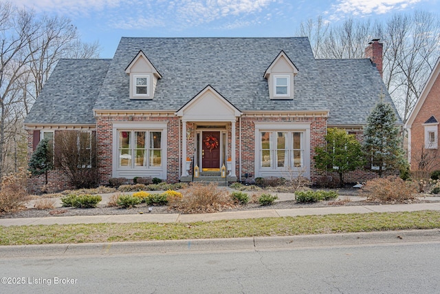 cape cod-style house with brick siding and a shingled roof