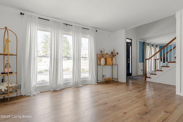 spare room featuring light wood finished floors and stairs