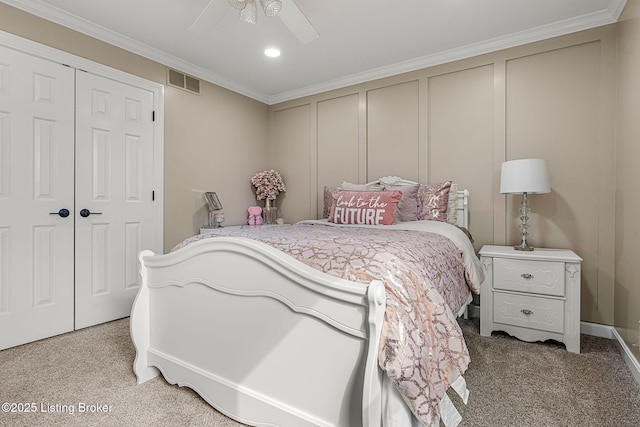 bedroom with visible vents, a ceiling fan, light colored carpet, crown molding, and a decorative wall