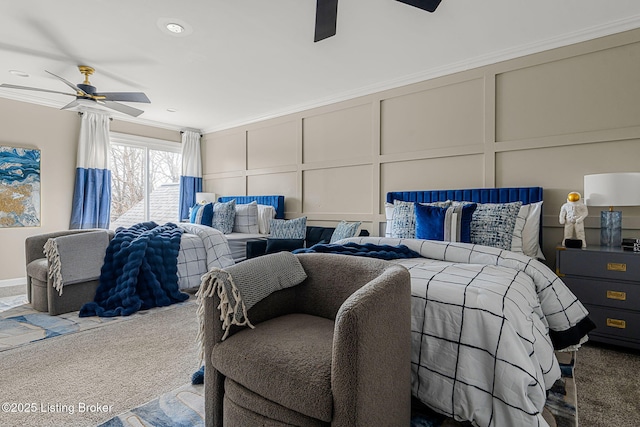 carpeted bedroom with ornamental molding, a decorative wall, and ceiling fan