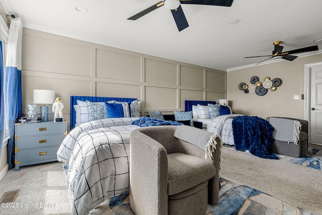 bedroom with ornamental molding, visible vents, a decorative wall, and ceiling fan