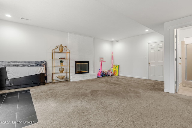 unfurnished living room featuring a brick fireplace, carpet, visible vents, and recessed lighting