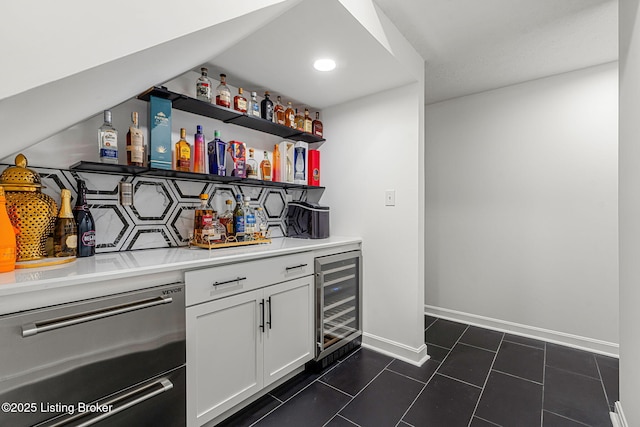 bar with wine cooler, a dry bar, decorative backsplash, dishwasher, and dark tile patterned floors