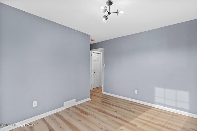 spare room featuring baseboards and wood finished floors