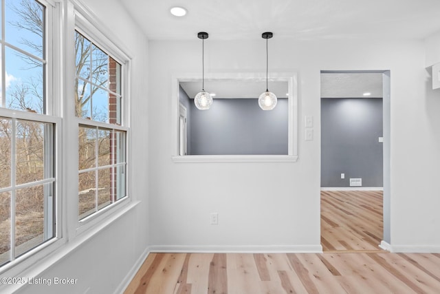 unfurnished dining area featuring recessed lighting, baseboards, and wood finished floors