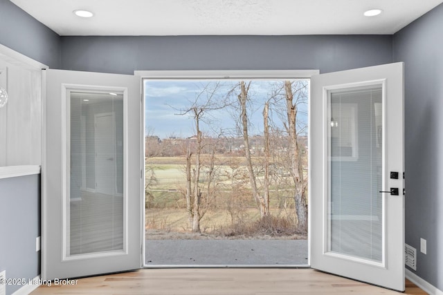 doorway to outside with wood finished floors and recessed lighting