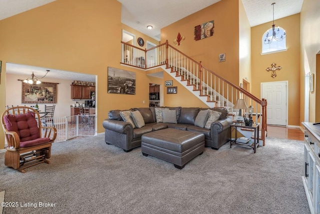 carpeted living room featuring a high ceiling, a chandelier, and stairs