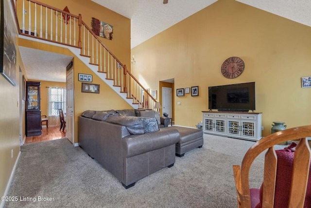 living area featuring stairway, carpet flooring, baseboards, and high vaulted ceiling