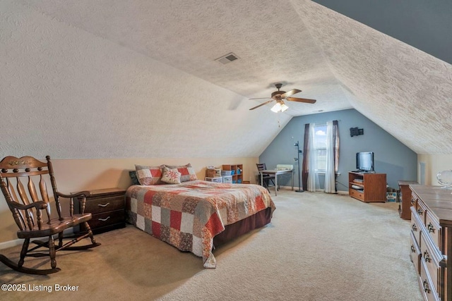 bedroom featuring visible vents, lofted ceiling, ceiling fan, a textured ceiling, and light carpet