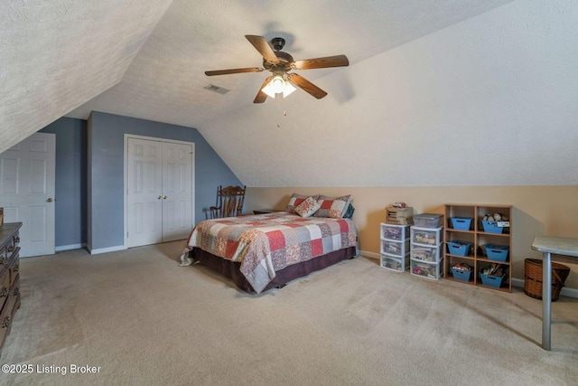 bedroom featuring visible vents, carpet floors, lofted ceiling, a closet, and a textured ceiling