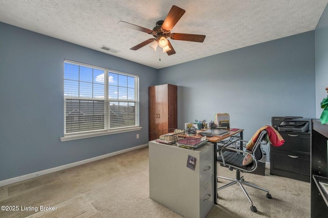 carpeted office space with visible vents, baseboards, a textured ceiling, and a ceiling fan