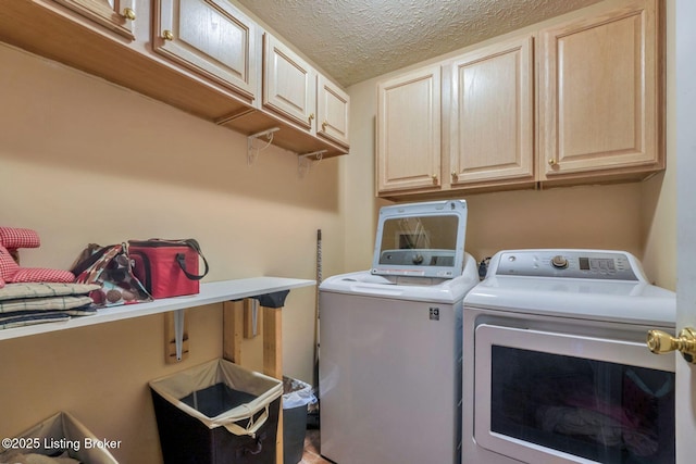 washroom with cabinet space, a textured ceiling, and independent washer and dryer