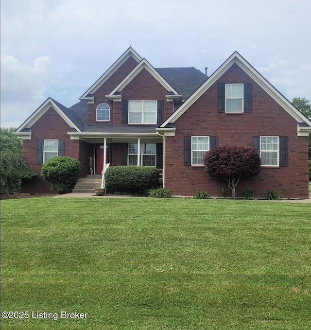 view of front of home with a front yard and brick siding