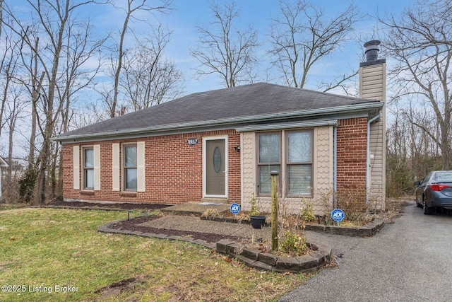 single story home featuring roof with shingles, a front lawn, a chimney, and aphalt driveway