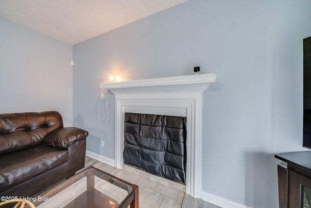 living area featuring a fireplace and baseboards